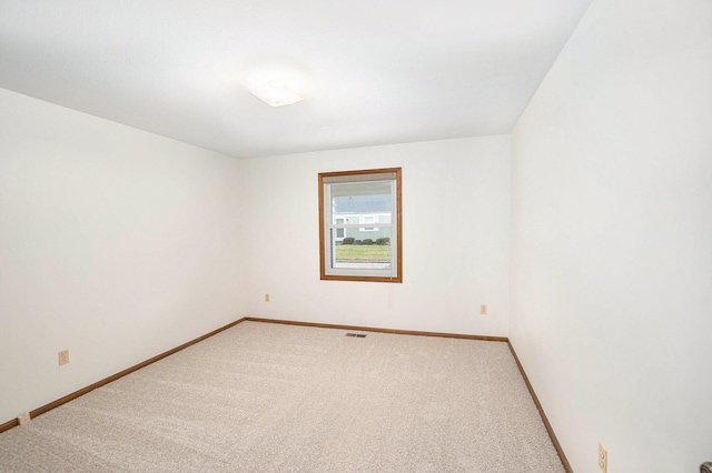 spare room with light colored carpet and baseboards