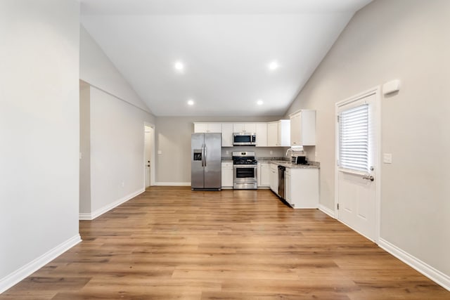 kitchen with light wood-type flooring, white cabinetry, appliances with stainless steel finishes, and baseboards