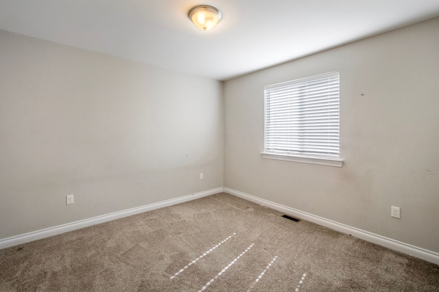 empty room with baseboards, visible vents, and carpet flooring