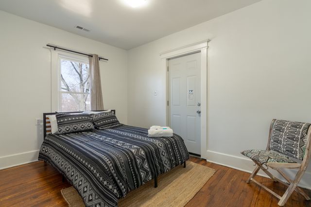 bedroom featuring baseboards, visible vents, and wood finished floors