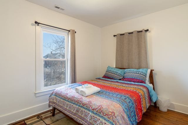 bedroom featuring visible vents, baseboards, and wood finished floors