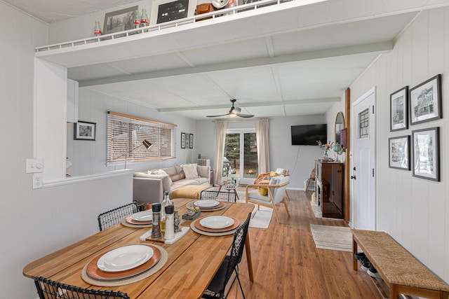 dining space featuring ceiling fan, beam ceiling, and wood finished floors