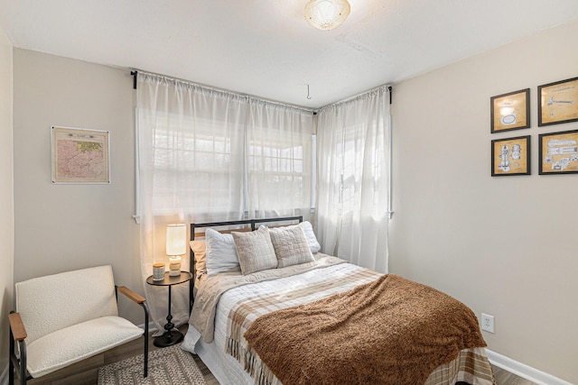 bedroom with baseboards and wood finished floors