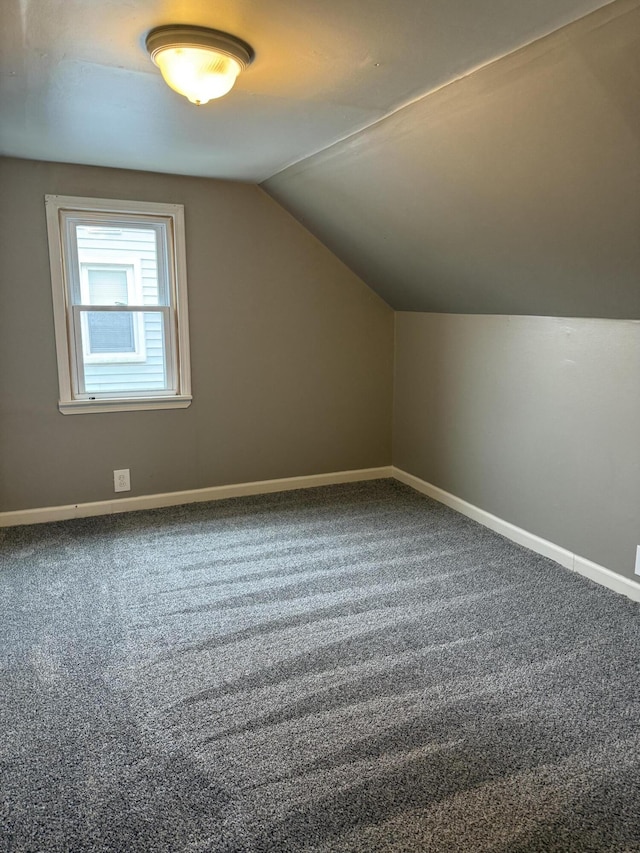 additional living space with carpet floors, baseboards, and vaulted ceiling