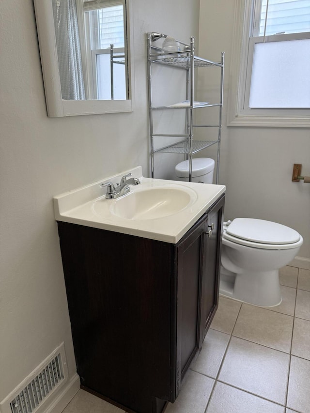 bathroom featuring visible vents, baseboards, toilet, tile patterned flooring, and vanity