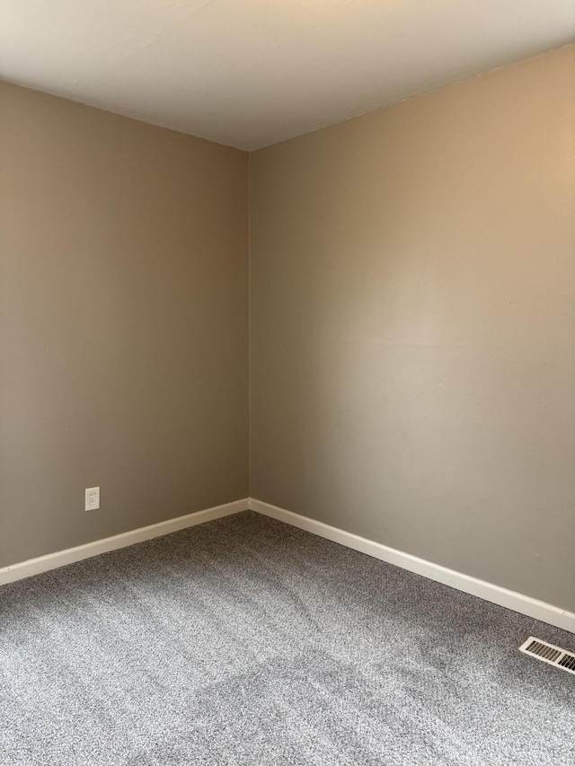 spare room featuring carpet flooring, visible vents, and baseboards