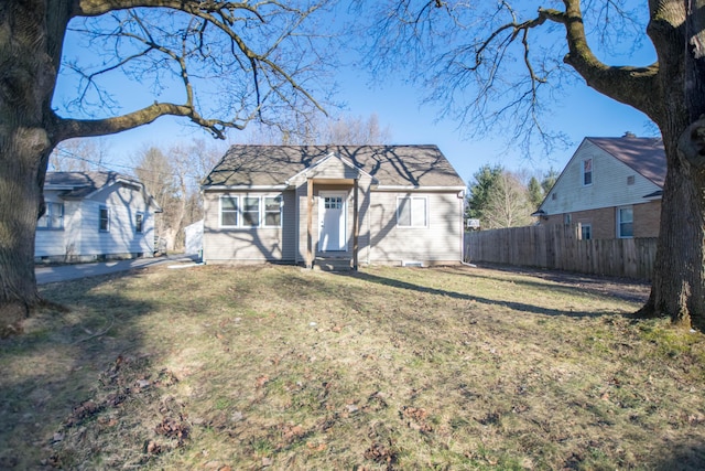 view of front of property with entry steps, fence, and a front yard