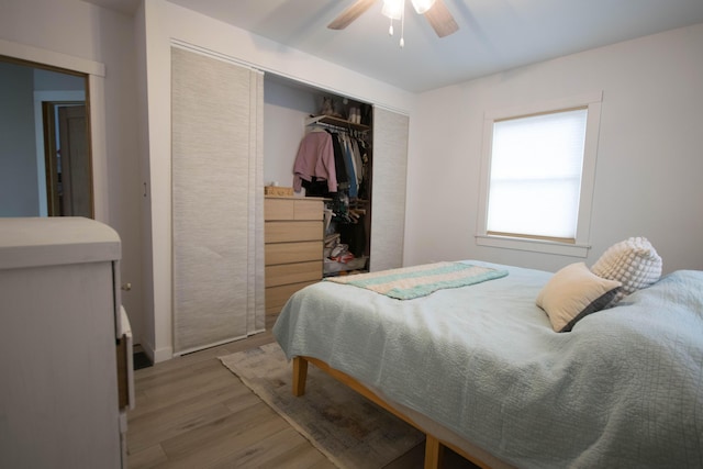 bedroom with ceiling fan, light wood finished floors, and a closet