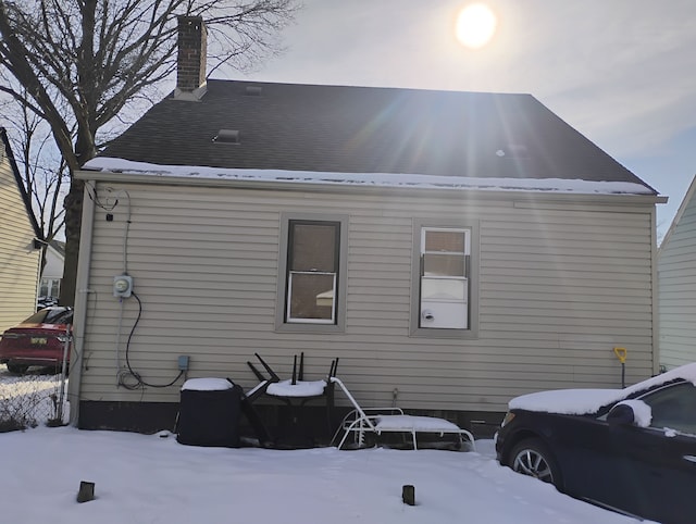 view of snow covered exterior with a chimney