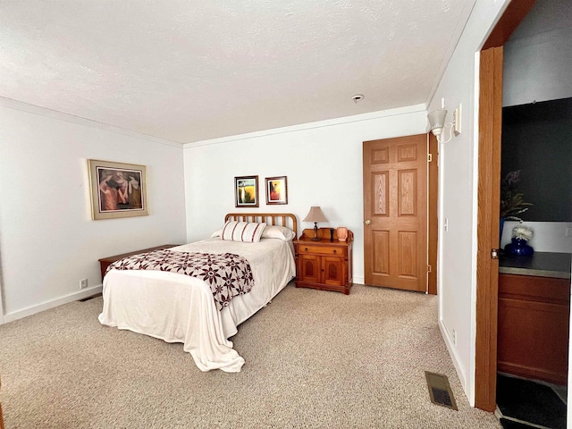 bedroom featuring light colored carpet, visible vents, and a textured ceiling