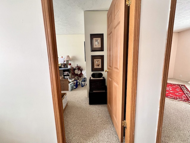 corridor featuring a textured ceiling and carpet