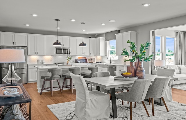 dining area with recessed lighting, plenty of natural light, and light wood-style flooring