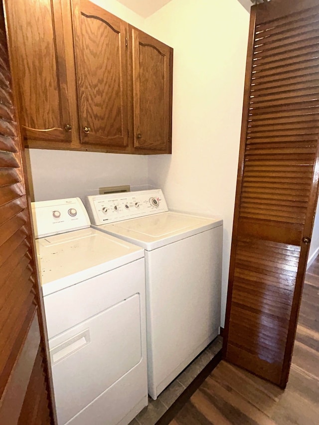 laundry room featuring cabinet space, dark wood-style floors, and washing machine and clothes dryer