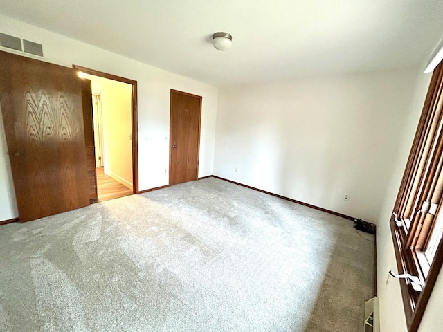 unfurnished bedroom with baseboards, visible vents, and carpet flooring