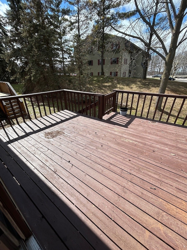 wooden deck featuring a lawn