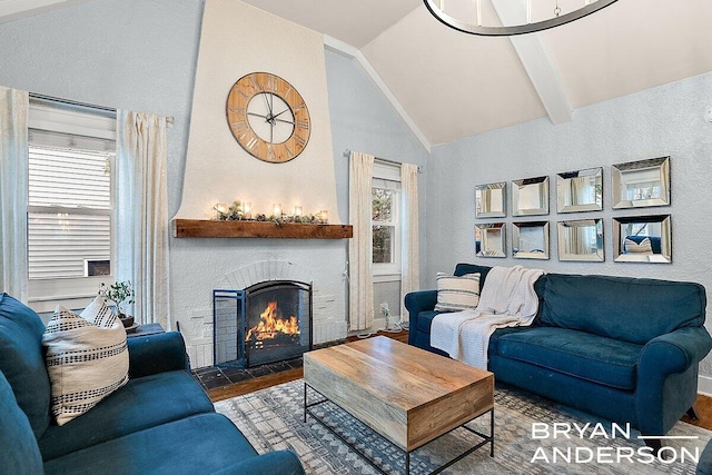 living area featuring a fireplace with flush hearth, a wealth of natural light, lofted ceiling with beams, and wood finished floors