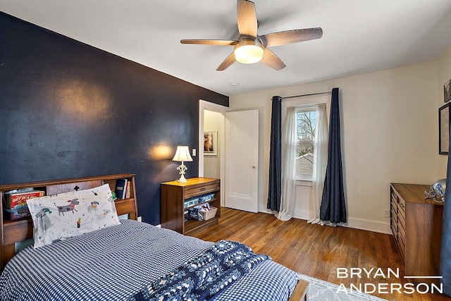 bedroom featuring a ceiling fan, baseboards, and wood finished floors