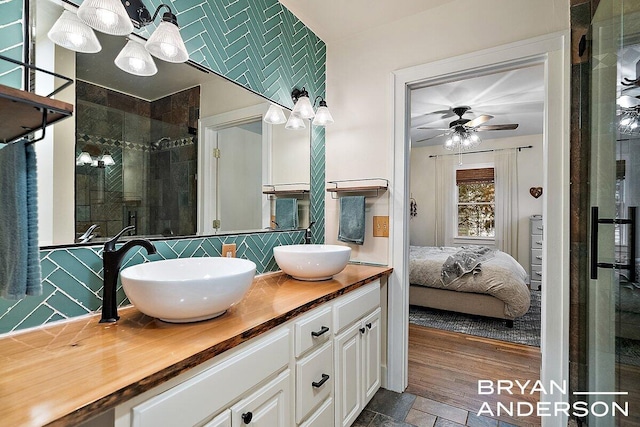 full bathroom featuring double vanity, tasteful backsplash, a sink, a shower stall, and ensuite bath