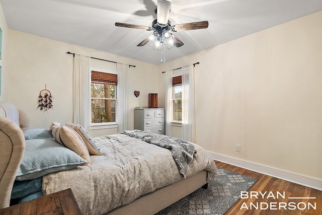 bedroom featuring ceiling fan, baseboards, and wood finished floors