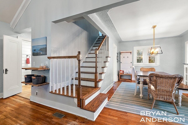 stairs with visible vents, baseboards, and wood finished floors