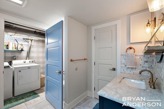 bathroom featuring vanity, visible vents, baseboards, tasteful backsplash, and washer and clothes dryer