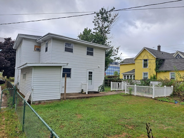 rear view of house with a fenced backyard and a yard