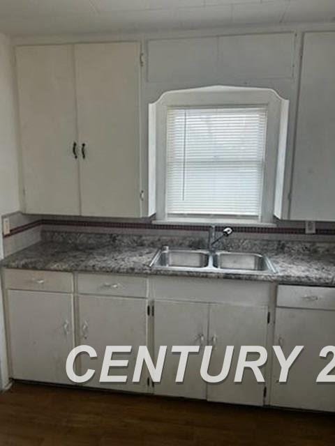 kitchen featuring dark wood-style floors, white cabinets, and a sink