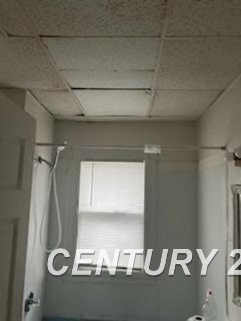 bathroom with a shower and a paneled ceiling