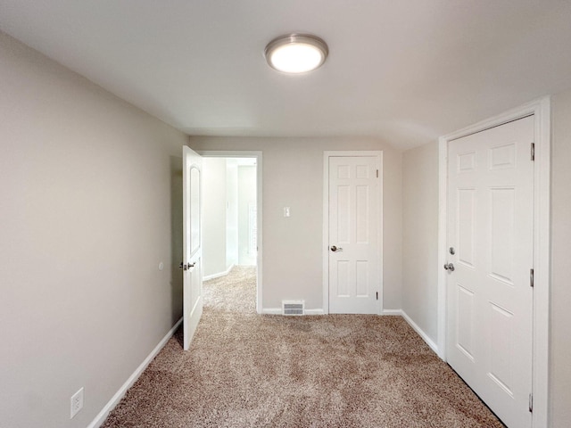 unfurnished bedroom featuring carpet floors, visible vents, and baseboards