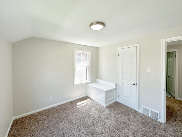 interior space featuring carpet, visible vents, vaulted ceiling, and baseboards