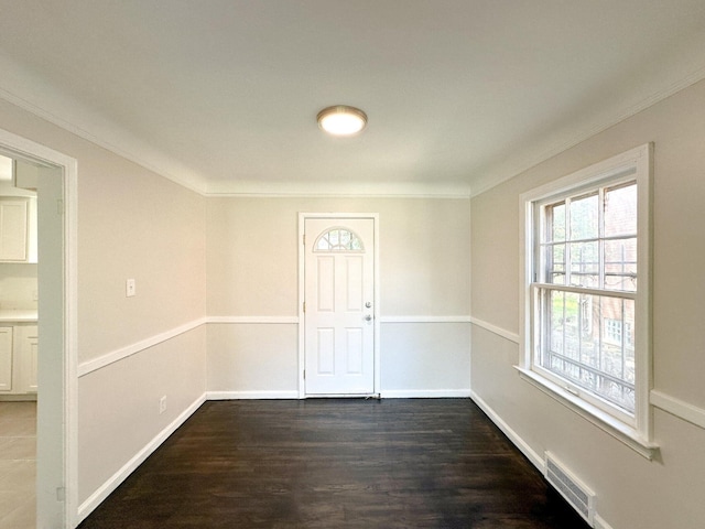 foyer entrance with ornamental molding, visible vents, baseboards, and dark wood-style floors