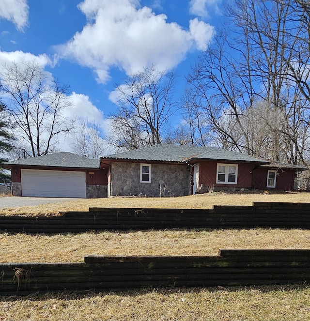 view of front of house featuring an attached garage and stone siding