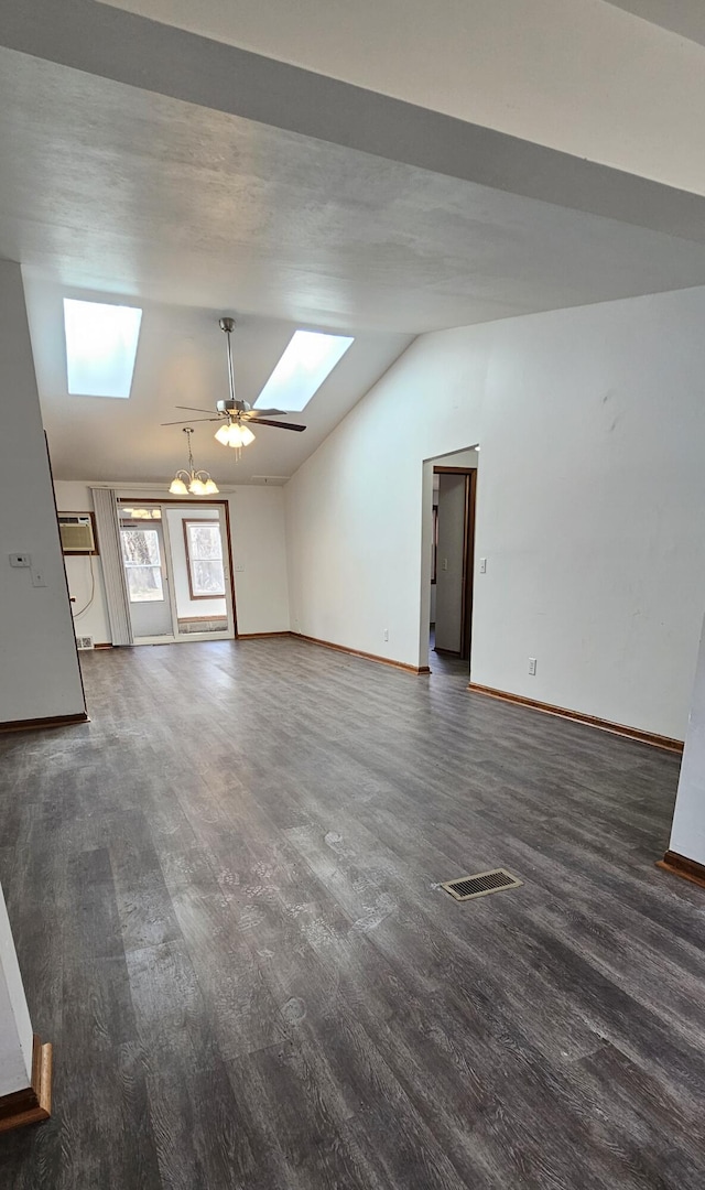 interior space featuring visible vents, a ceiling fan, wood finished floors, vaulted ceiling with skylight, and baseboards