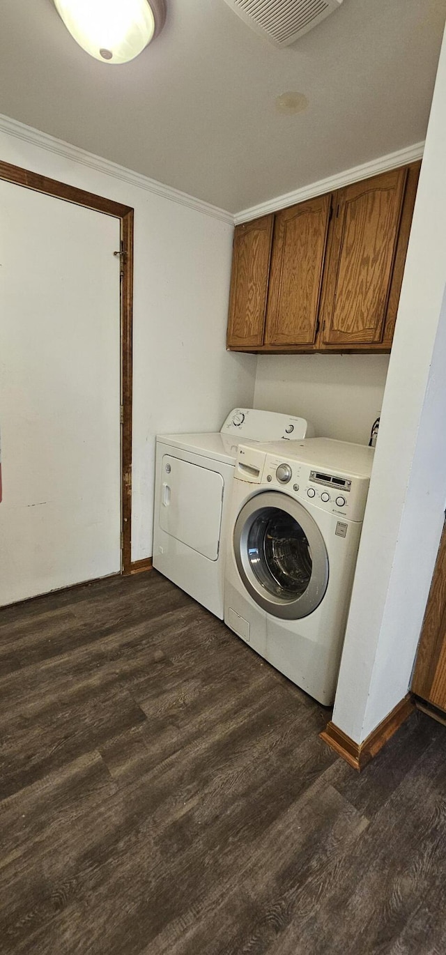 laundry room with dark wood-style floors, crown molding, cabinet space, visible vents, and independent washer and dryer