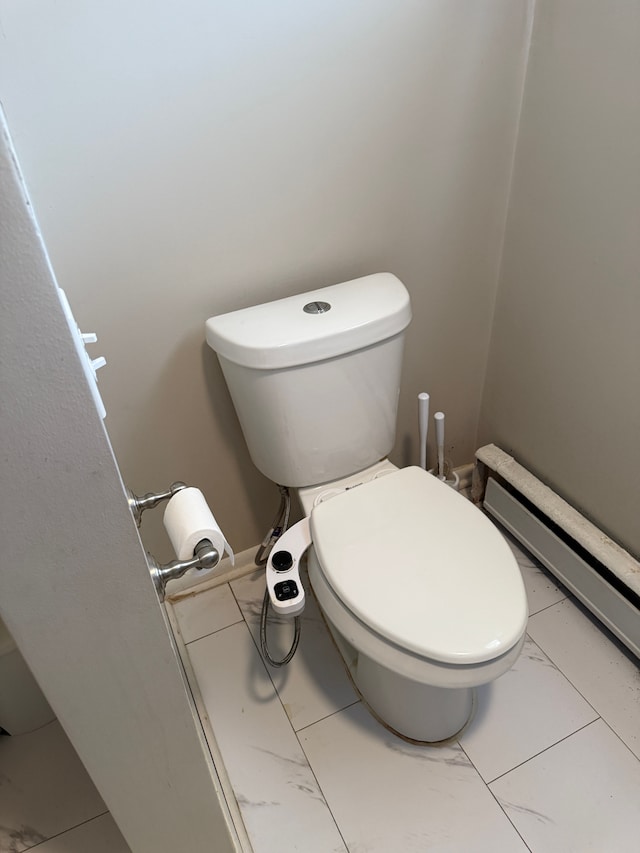 bathroom with toilet and marble finish floor