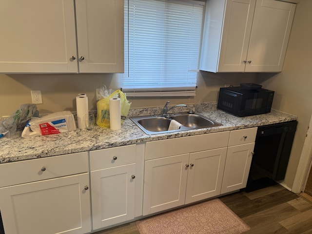 kitchen with white cabinetry, black appliances, light countertops, and a sink
