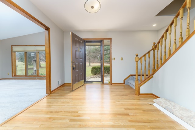 entrance foyer with visible vents, stairway, baseboards, and wood finished floors