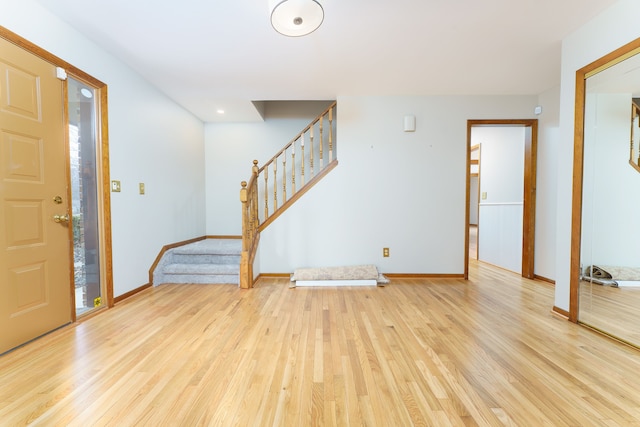 foyer featuring light wood-style floors, stairway, and baseboards