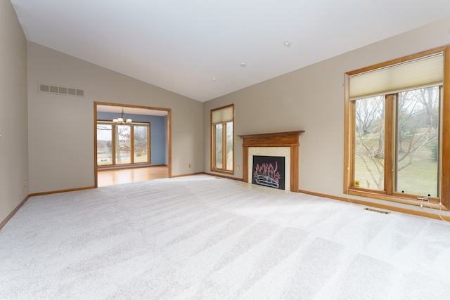 unfurnished living room featuring a healthy amount of sunlight, visible vents, and light colored carpet