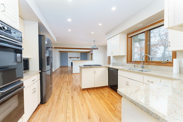 kitchen with recessed lighting, a peninsula, a sink, light wood-type flooring, and black appliances