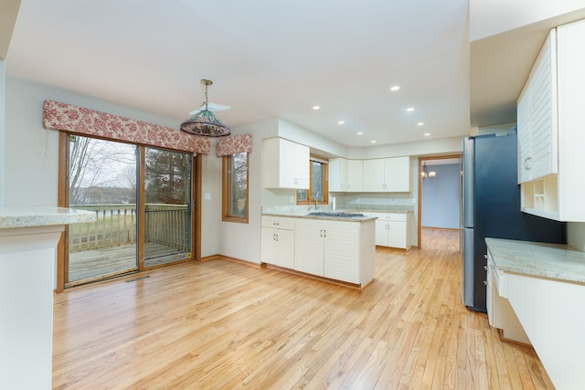 kitchen featuring light wood finished floors, freestanding refrigerator, decorative light fixtures, white cabinetry, and recessed lighting