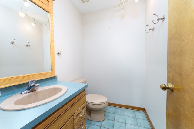 bathroom featuring baseboards, visible vents, toilet, tile patterned floors, and vanity