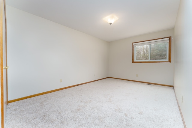 carpeted spare room featuring visible vents and baseboards