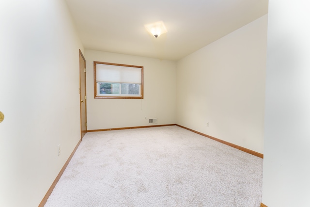 unfurnished room with carpet flooring, visible vents, and baseboards