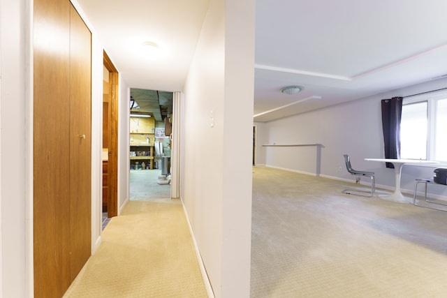 corridor featuring light carpet and baseboards