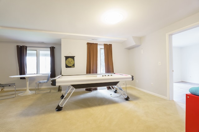 recreation room featuring light carpet and baseboards