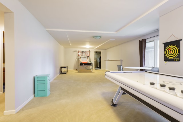 recreation room featuring light colored carpet and baseboards