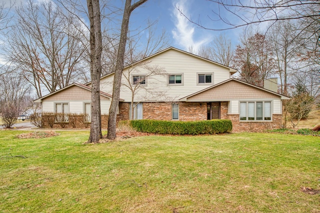 traditional-style home with brick siding, a chimney, and a front yard