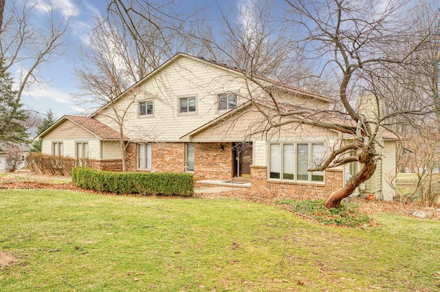 view of front of property featuring brick siding and a front lawn