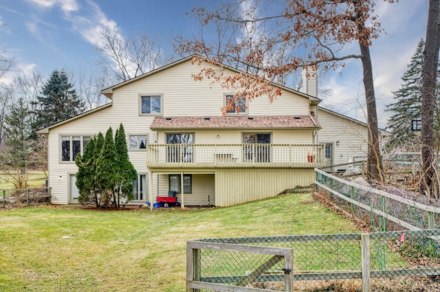 back of house featuring a lawn, a chimney, and fence